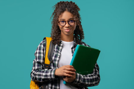 Portrait of high school smiling african american student girl with papers folder. Academic teen,...