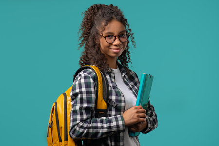 College smiling african student girl or schoolgirl with papers folder. Education