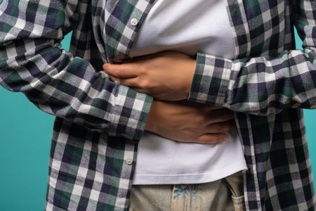 Hands of girl squeezing belly with hands. abdominal pain, suffering stomach acheの写真素材