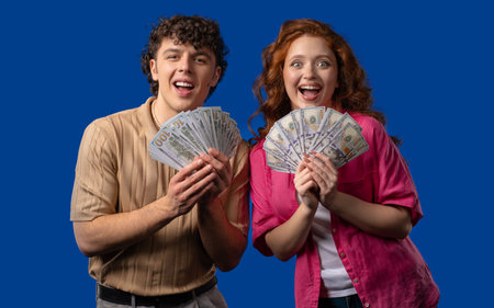 Rich couple, USD currency. Young man and woman with money on blue, happy pair
