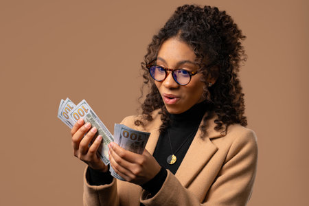 Rich African Stylish Woman Counting Usd Cash Money Dollars Banknotes On Beigeの写真素材