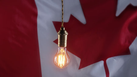 classic antique Edison Tungsten filament lamp on waving canadian flag background. Creative idea, realization, discovery, eurekaの写真素材