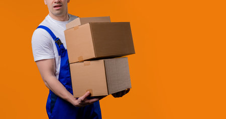 Postal courier,handyman with heavy parcels boxes.Man delivers packages, hard job. Copy spaceの写真素材