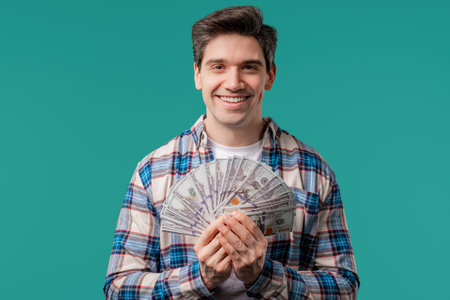 Rich excited man with cash money USD currency dollars banknotes on blue,jackpotの写真素材