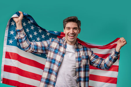 Happy mature man with national USA flag on blue background. American patriotの写真素材
