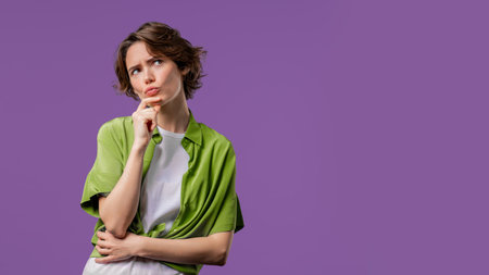 Thinking around stylish woman on violet background. Puzzled lady looking answer. Copy space.の写真素材