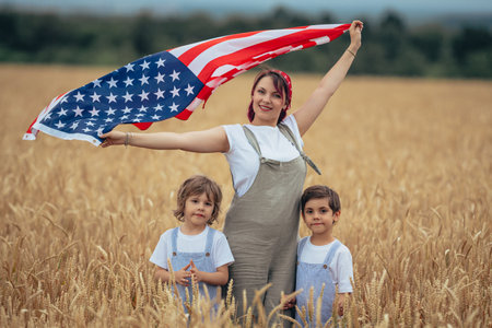 Family of Patriots - Woman Mother with boys kids holding american national flag In Rural Wheat Field. democracy, independence, USA, 4th July celebration, US banner, electionの写真素材