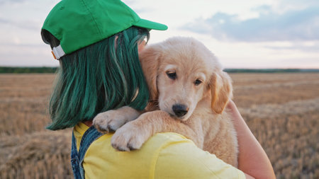 Sweet Golden Retriever Puppy With Its Owner Woman Walking On Hands. Happy Dogの写真素材