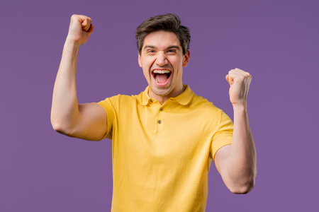 Handsome man on violet,shows triumph yes YEAH gesture of victory,achieved resultの写真素材