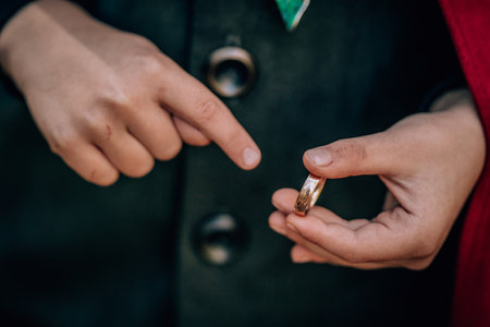 Hands of boy cosplayer in hobbit cape costume holding and wants to wear golden ring. Fantasy journey, halloween, fellowship cosplayの写真素材