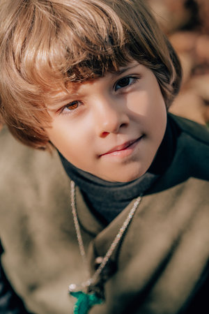 Portrait of hobbit boy in cape costume in autumn forest. Fantasy journey, halloween, fellowship cosplayの写真素材