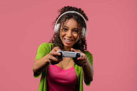Young african woman playing and win online video game on console with joystickの写真素材