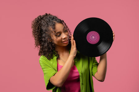 Young african woman with vinyl record disc. Hobby, Music Lover, Collectionの写真素材