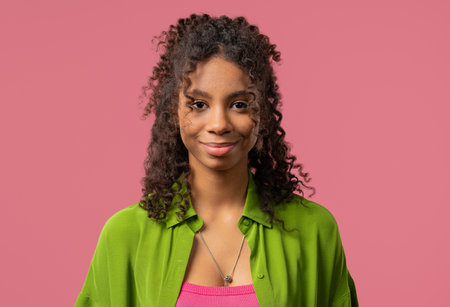 Young African Woman With Kind Smile Looking To Camera On pink Studioの写真素材