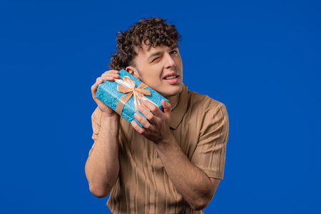 Happy Hipster Man With Gift Box, Blue Background. Guy Smiling, Whats Inside.の写真素材