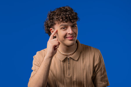 Handsome clever man with gesture - you, think about it. Looking camera on blueの写真素材