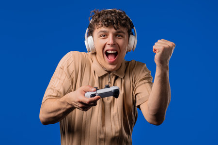 Young adult man playing online video game on console TV with joystick.の写真素材