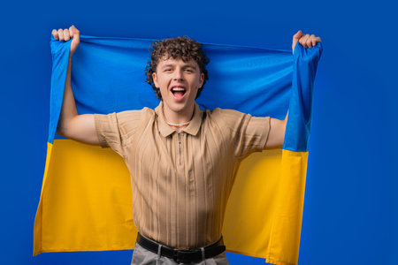 Happy young man with national Ukrainian flag. Ukraine, patriot, victory, fanの写真素材