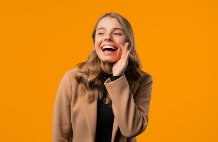 portrait of businesswoman shouting, holding hand near open mouthの写真素材
