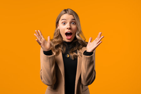 Surprised businesswoman, she expresses WOW, cant believe. Impressed lady trying to get attention. Concept of sales, profitable offer. Excited girl on yellow backgroundの写真素材