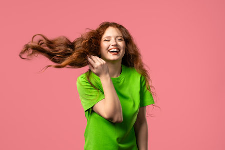Happy woman dancing beautiful long ginger natural hair. Woman shaking head, pinkの写真素材