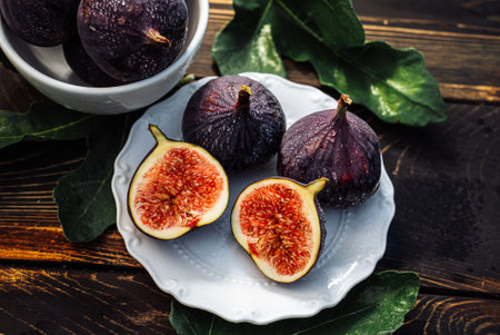Delicate Fresh Ripe Figs With Leaves On White Plate, Rustic Wooden Table. Ficusの写真素材