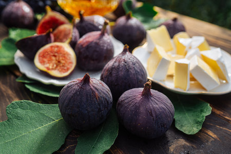 Cheese platter with camembert brie, healthy juicy organic figs, honey and grapesの写真素材