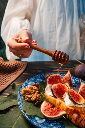 Sweet Golden Honey Pouring On Ripe Figs Slices, Walnuts. Healthy Breakfastの写真素材