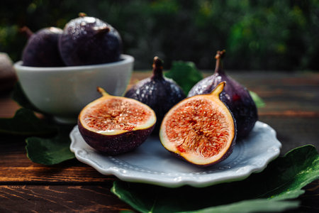 Delicate Fresh Ripe Figs With Leaves On White Plate, Rustic Wooden Table. Ficusの写真素材