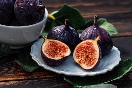 Delicate Fresh Ripe Figs With Leaves On White Plate, Rustic Wooden Table. Ficusの写真素材