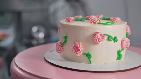 Elegant cake on turntable.Pink buttercream flowers on frosting. Bakery, pastry
