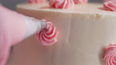 Chef Hands Decorating Bento Cake with Cream Roses. Pastry Art, Floral Details.の写真素材