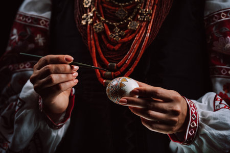 Ukrainian woman painting traditional ornamets on Easter egg - pysanka.の写真素材