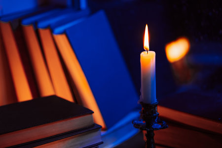 Vintage background. Stack of paper books near rainy window. Bronze candlestick.の写真素材