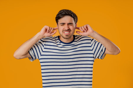 Annoyed Man With Shut Ears On Yellow. Guy Block Annoying Sounds, Loud Music