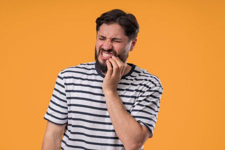 Bearded Man Touching Cheek With Painful Expression, Reacting To Sudden Toothache