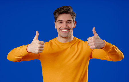 Handsome Man With Hand Sign Like, Thumbs Up Gesture.happy Guy On Blue Studio