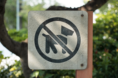 Closeup no pets allowed sign with light shade in the park