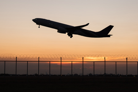 Closeup silhouette takeoff plane from the airport while dawnの写真素材