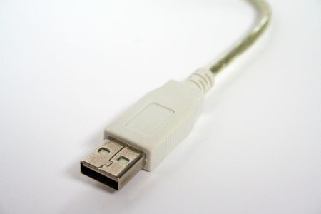 Close-up of a usb connector cable. The plug itself is white and the cable is transparent.