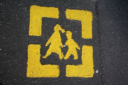 This sign on the sidewalk is for children to show them the way to school. And for adults, to tell them to watch out for school children. Found in Germany.の写真素材