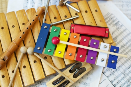 Some typical, colorful music instruments as used mostly by children. The musical score in the...