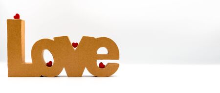 Inscription LOVE made from cardboard. 4 small red heartsの写真素材