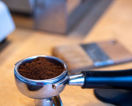 A close shot of the portafilter of coffee machine with a fresh ground coffee.の写真素材