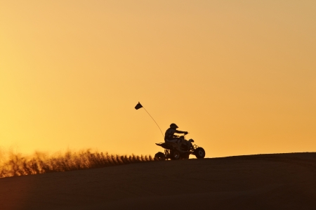 Quad-bike in Glamis sand Dunes during sunset Quad-bike in Glamis sand Dunes during sunset