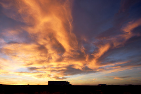 Truck on Highway under dramatic sky at dusk.の写真素材