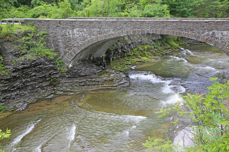 Taughannock Creek flowing under stony bridge- New Yorkの写真素材