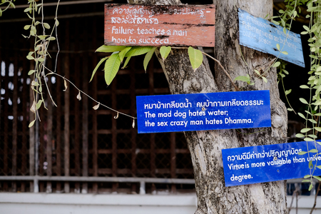 Chiangmai, Thailand - December 18, 2014: Wooden and plastic label of quote about Dhamma and goodness at Kuu Kham Temple Amphoe Mueang Chiangmai, Thailandのeditorial素材