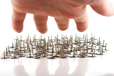 Hand above thumb tacks - drawing pins, isolated on whiteの写真素材