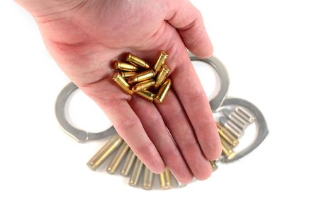 hand and bullets with handcuffs and bullets in the backgroundの写真素材